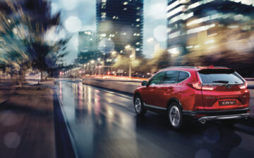 Carro Honda vermelho a conduzir com chuva