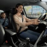 vista interior de um Honda com uma mulher a conduzir com uma criança no banco de trás.