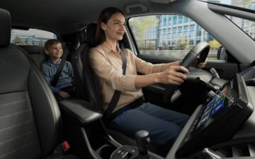 vista interior de um Honda com uma mulher a conduzir com uma criança no banco de trás.