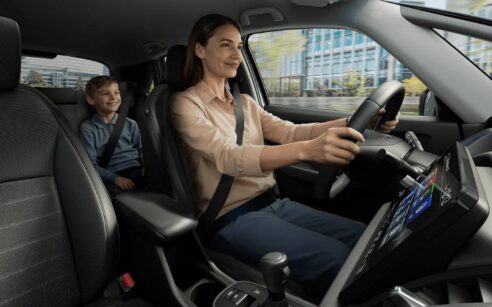 vista interior de um Honda com uma mulher a conduzir com uma criança no banco de trás.