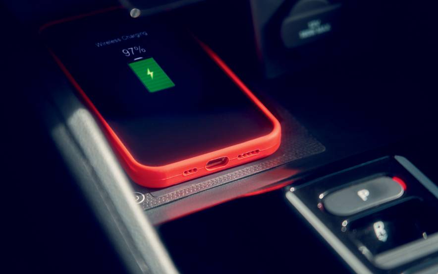 Telemóvel a ser carregado por indução, numa tecnologia automóvel integrada nos carros Honda.