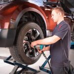 Mecânico a trocar um pneu furado numa oficina