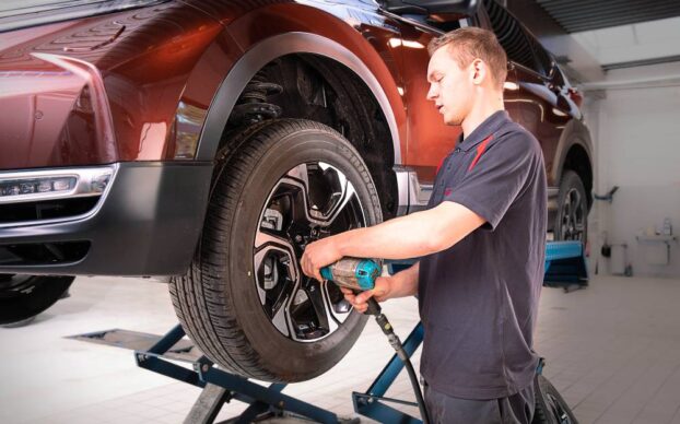 Mecânico a trocar um pneu furado numa oficina